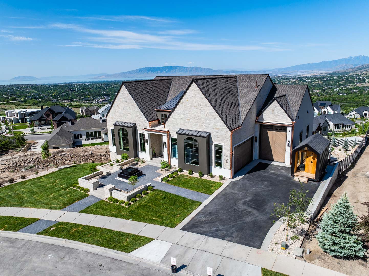 Front exterior of luxury custom home with manicured landscaping in Room with a View featured in the 2025 Utah Valley Parade of Homes by E Builders