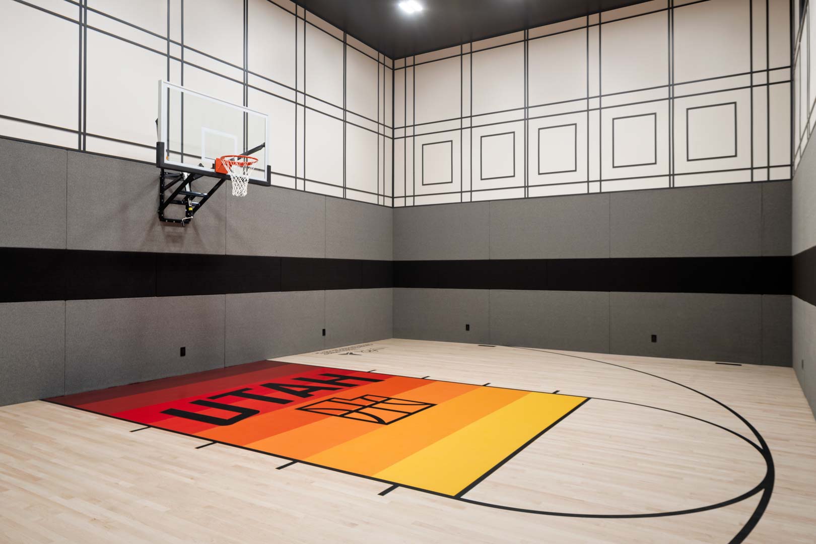 Indoor basketball court with Utah-themed floor design in custom home Room with a View featured in the 2025 Utah Valley Parade of Homes by E Builders