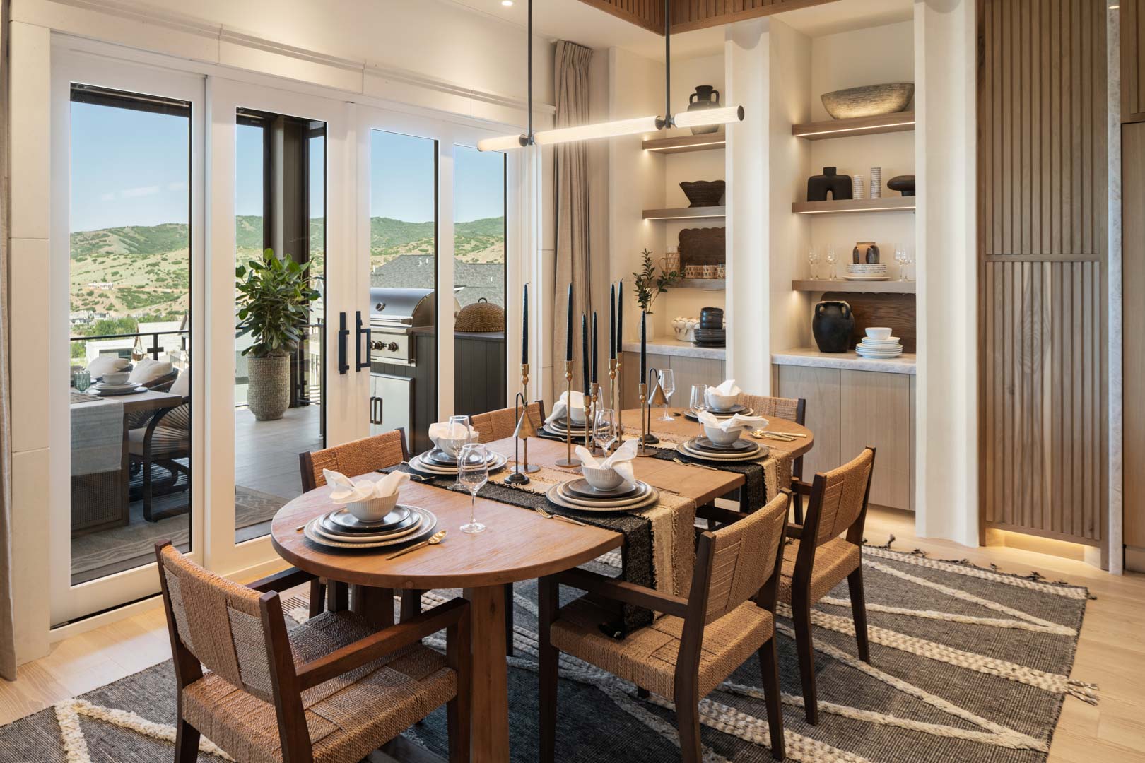 Intimate dining setting with warm tones and outdoor access in custom home Room with a View featured in the 2025 Utah Valley Parade of Homes by E Builders