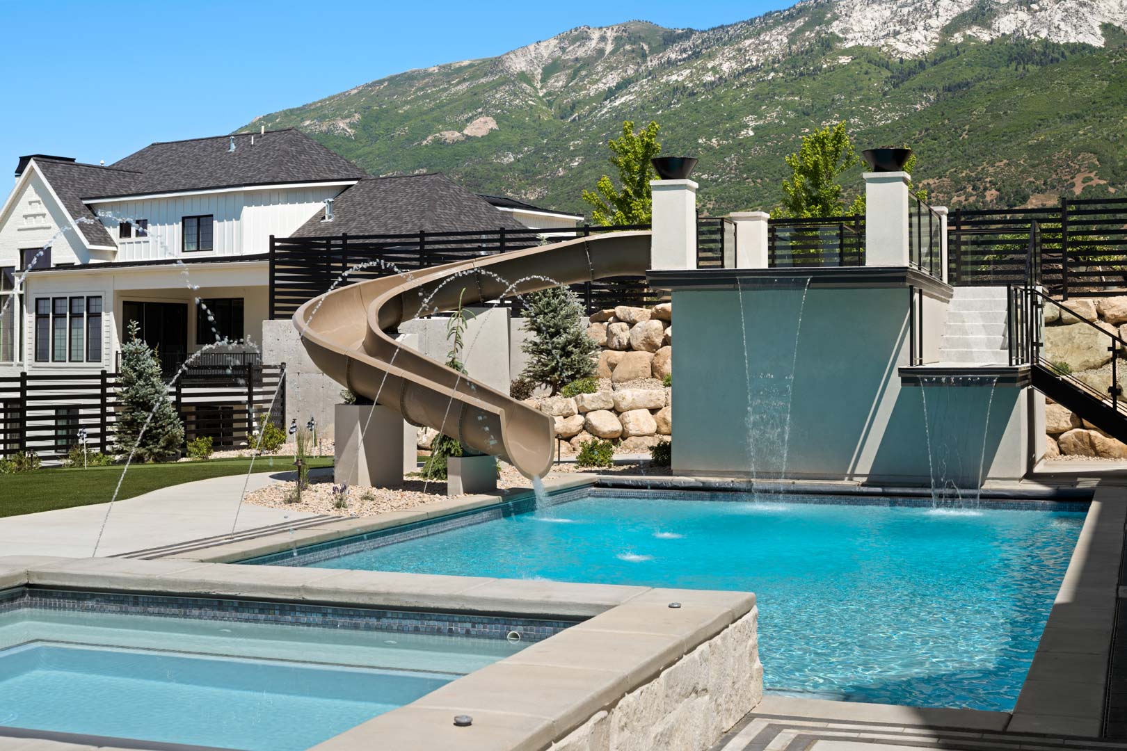 Luxury outdoor pool and slide at custom home Room with a View featured in the 2025 Utah Valley Parade of Homes by E Builders