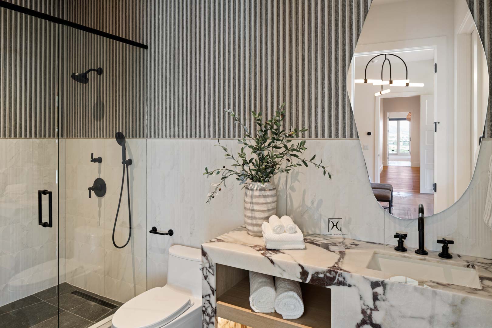 Modern guest bath with striped accent wall and dark fixtures in custom home Room with a View featured in the 2025 Utah Valley Parade of Homes by E Builders