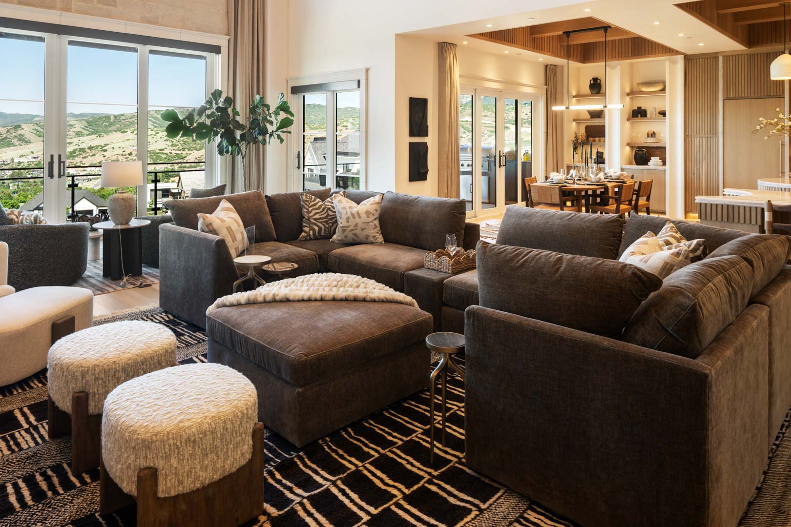 Open-concept great room with sectional sofa and view into dining area in custom home Room with a View featured in the 2025 Utah Valley Parade of Homes by E Builders