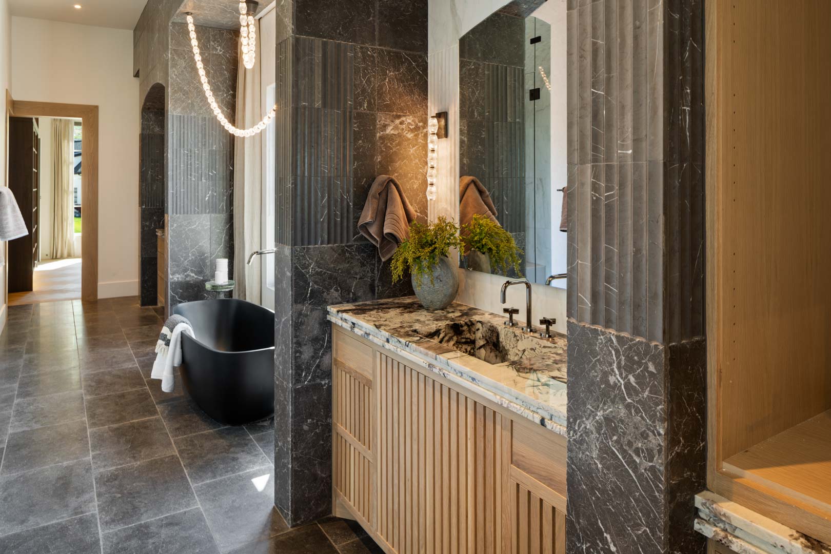 Primary bathroom with custom marble vanity and black soaking tub in custom home Room with a View featured in the 2025 Utah Valley Parade of Homes by E Builders