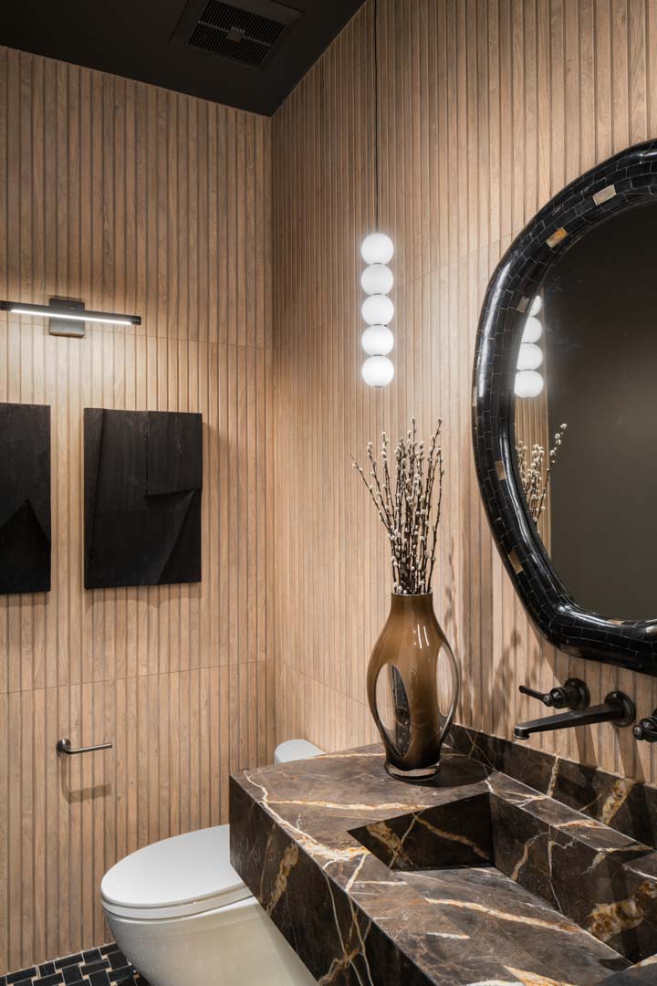 Sophisticated half bath with modern lighting and round mirror in custom home Room with a View featured in the 2025 Utah Valley Parade of Homes by E Builders
