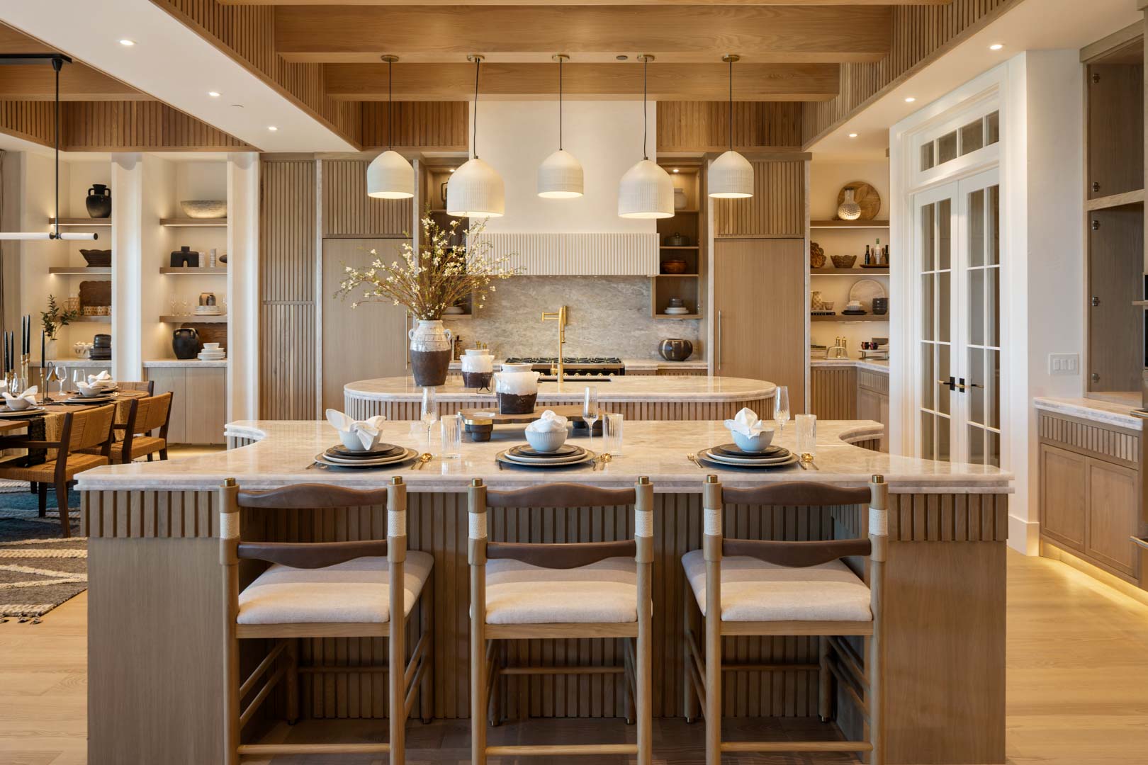 Sophisticated kitchen design with waterfall countertops in custom home Room with a View featured in the 2025 Utah Valley Parade of Homes by E Builders