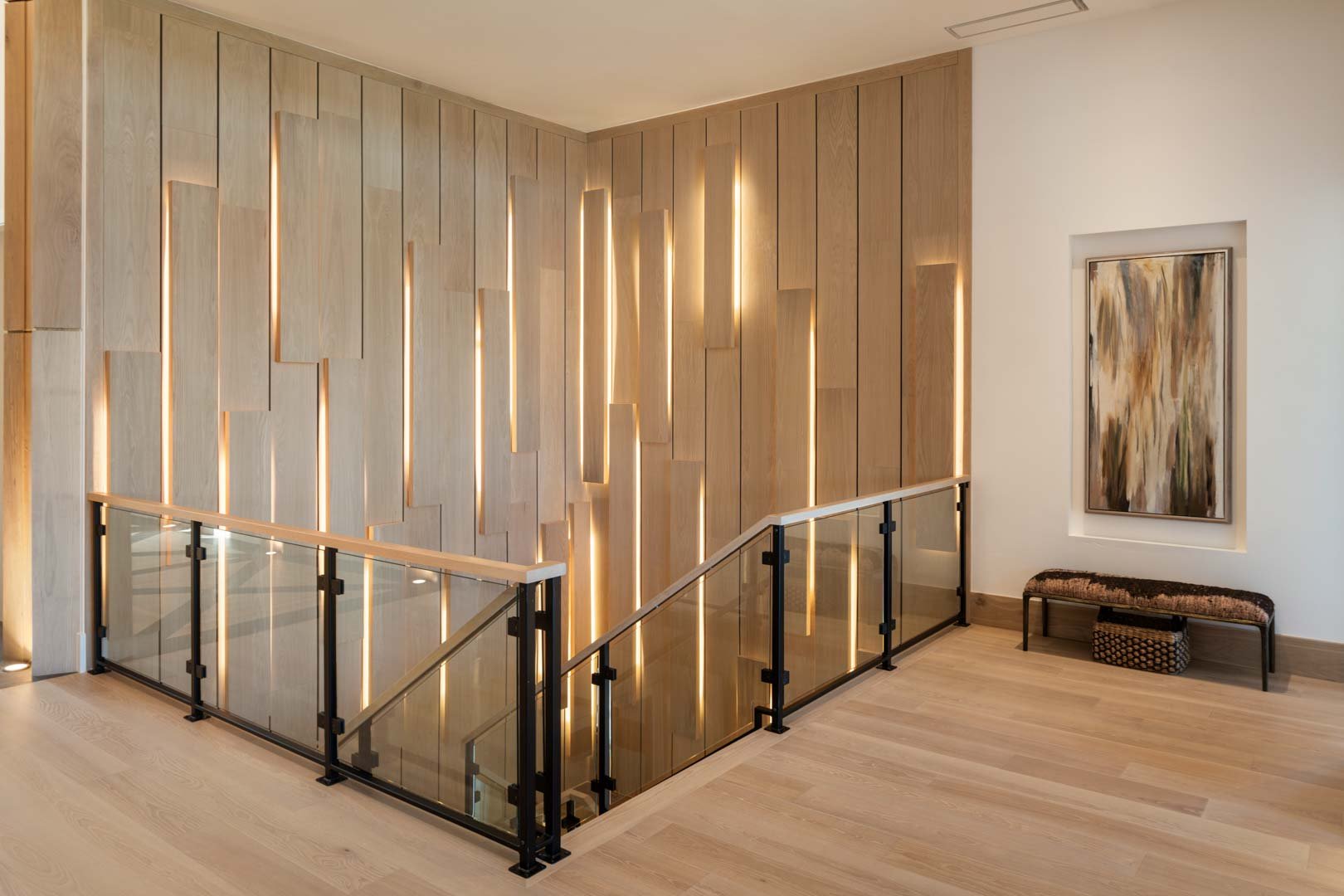 Staircase with custom backlit wood paneling in custom home Room with a View featured in the 2025 Utah Valley Parade of Homes by E Builders