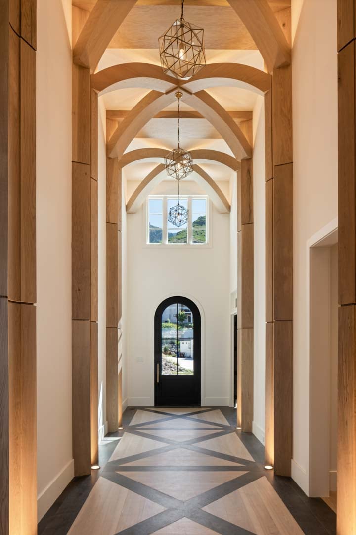 Vaulted entryway with geometric wood beams in custom home Room with a View featured in the 2025 Utah Valley Parade of Homes by E Builders