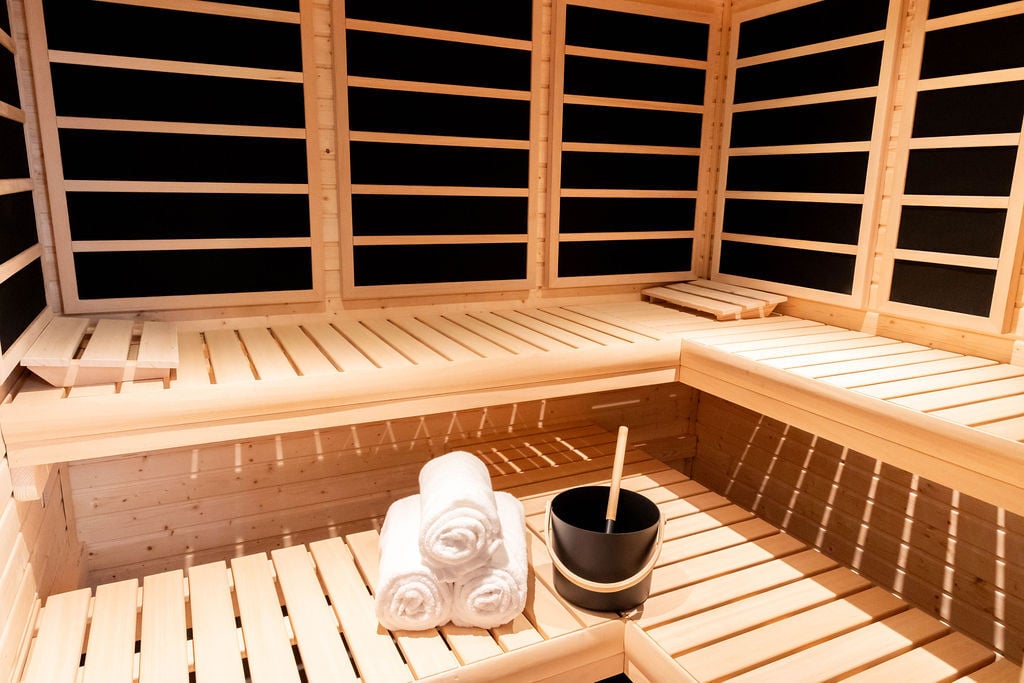 Warm wood sauna room with bench seating and towel setup in the Room with a View custom home featured in the 2025 Utah Valley Parade of Homes by E Builders