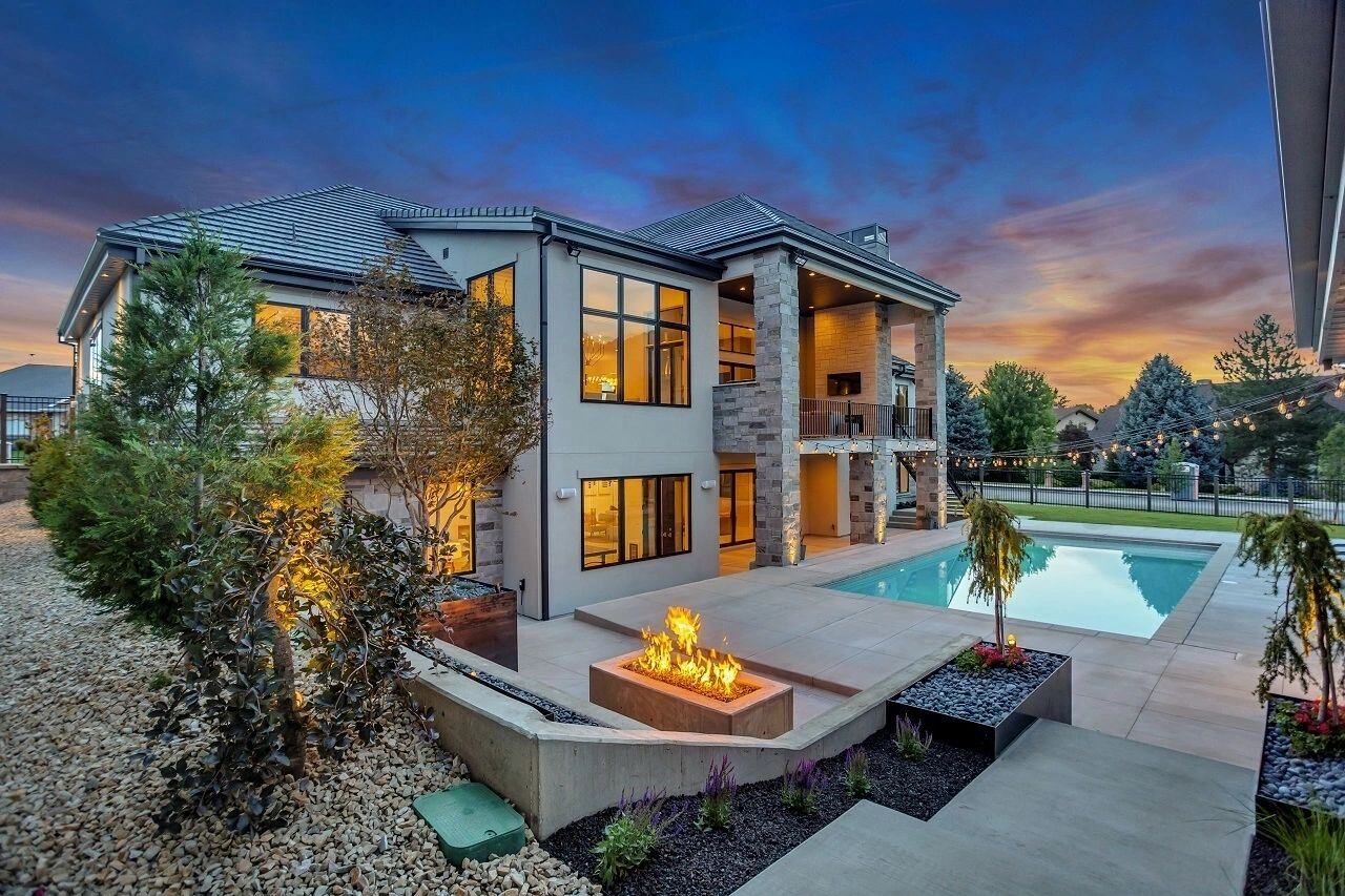 Fire pit and poolside landscaping at dusk in a custom home in Salt Lake City, UT built by E Builders