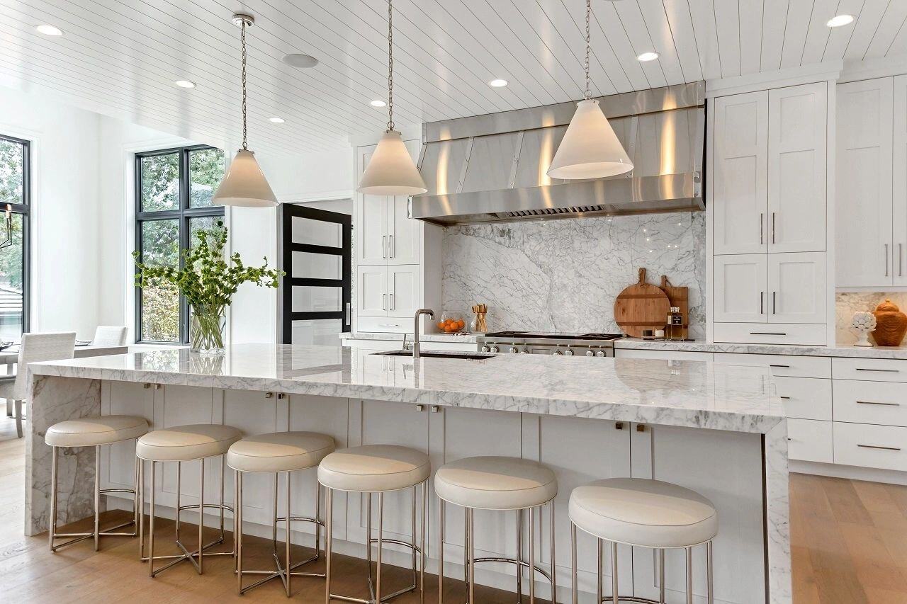 Modern white kitchen with marble countertops and natural light in a custom home in Salt Lake City, UT built by E Builders