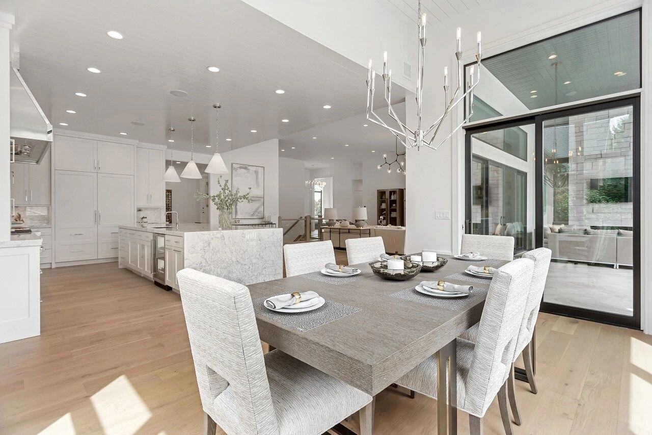 Open dining space with wood table and upholstered chairs in a custom home in Salt Lake City, UT built by E Builders