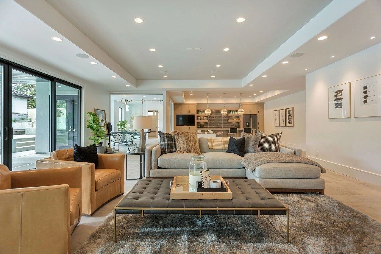 Open-concept family room with large sectional and kitchen views in a custom home in Salt Lake City, UT built by E Builders