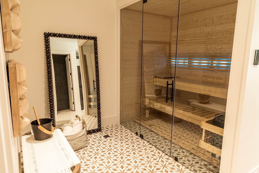 Basement wellness area with wood-lined sauna and patterned flooring in a custom home featured in the 2025 Utah Valley Parade of Homes