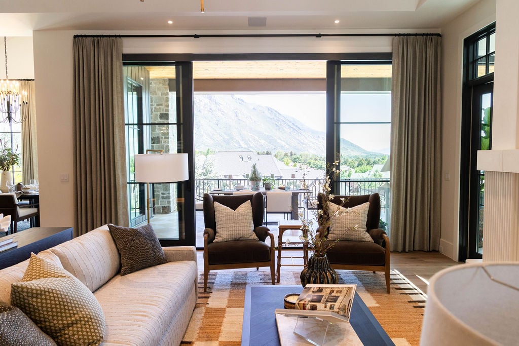 Bright living space with custom floor-to-ceiling windows overlooking mountain views in a custom home featured in the 2025 Utah Valley Parade of Homes