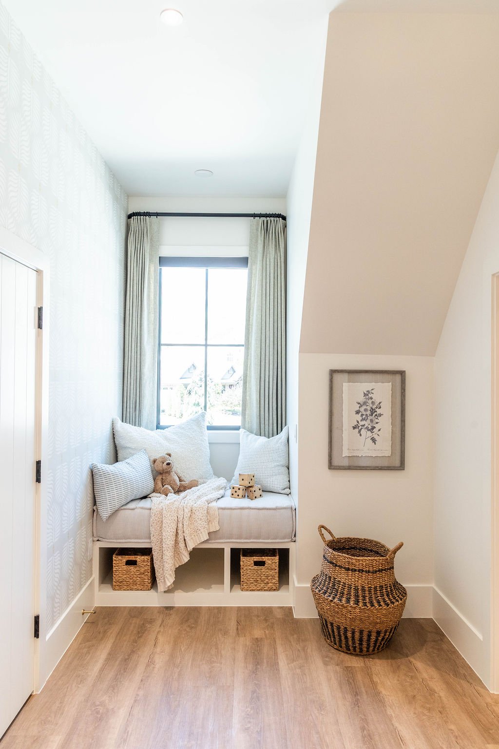 Built-in window bench with neutral cushions and toy accents in a custom home featured in the 2025 Utah Valley Parade of Homes