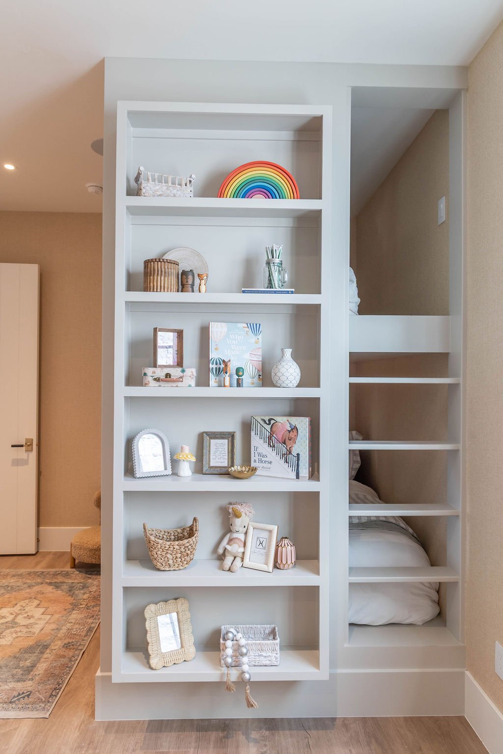 Bunk beds with built-in bookshelf in a children’s bedroom, part of a custom home featured in the 2025 Utah Valley Parade of Homes