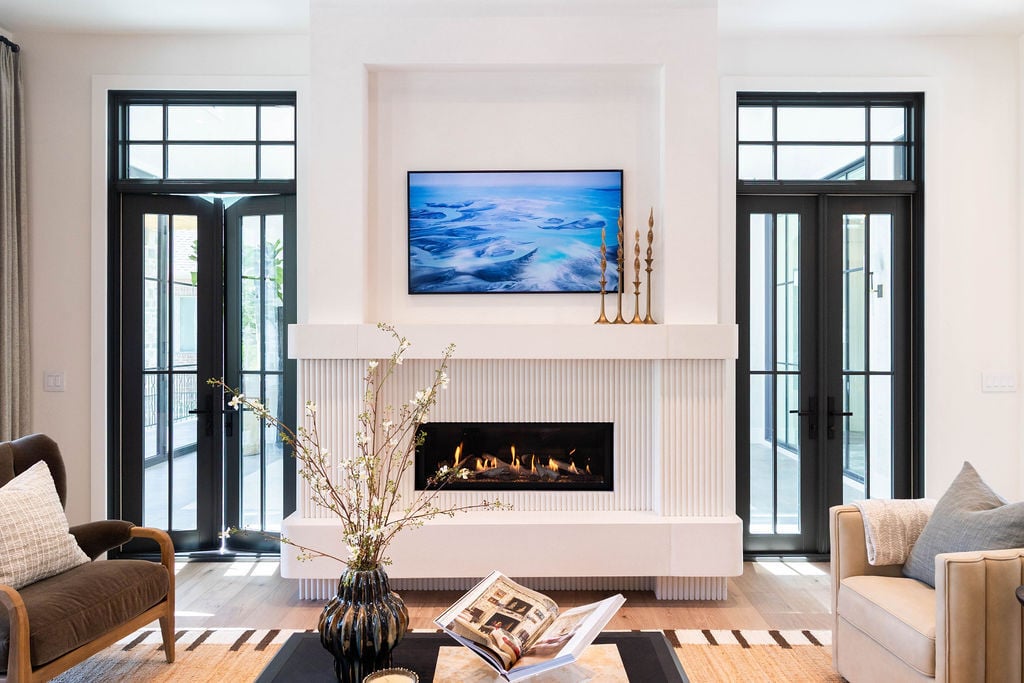 Custom fireplace wall with TV and elegant lighting in a great room featured in the 2025 Utah Valley Parade of Homes