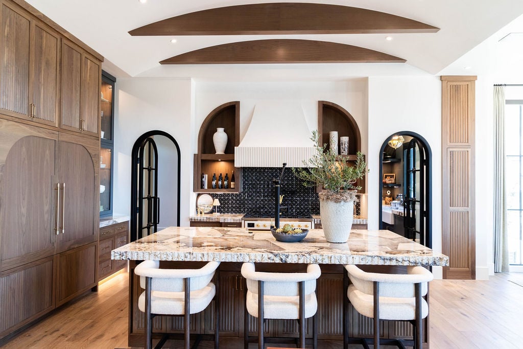 Full kitchen and great room view with bold ceiling beams and natural wood elements in a custom home featured in the 2025 Utah Valley Parade of Homes