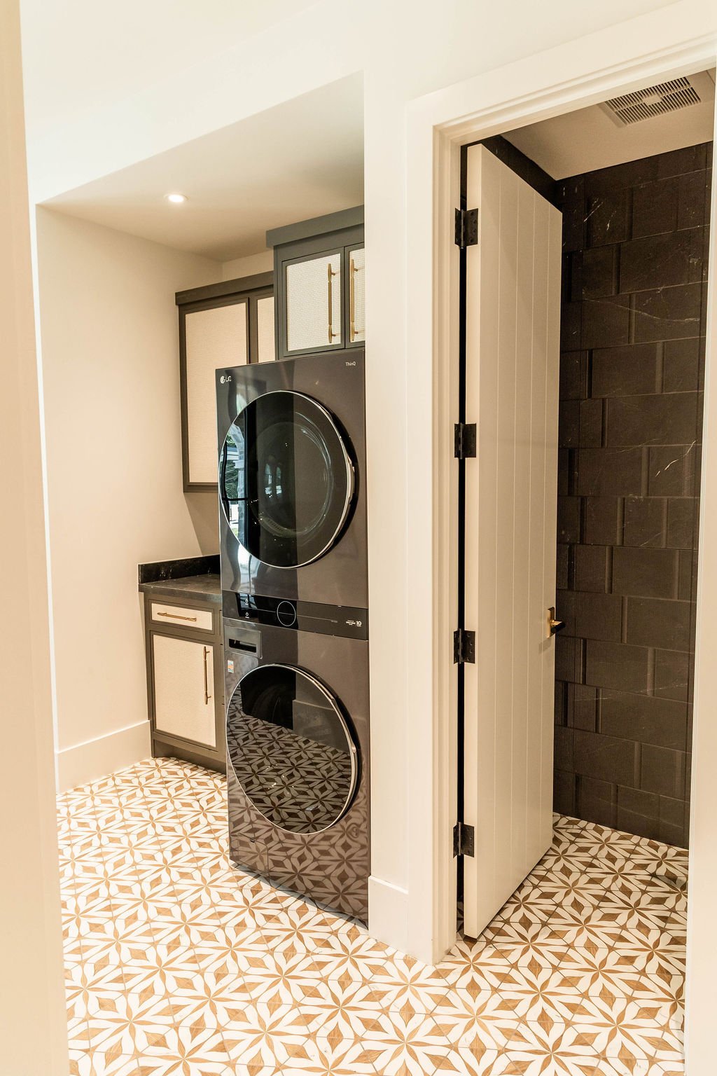 Laundry room with LG stacked units and bold patterned tile in a custom home featured in the 2025 Utah Valley Parade of Homes