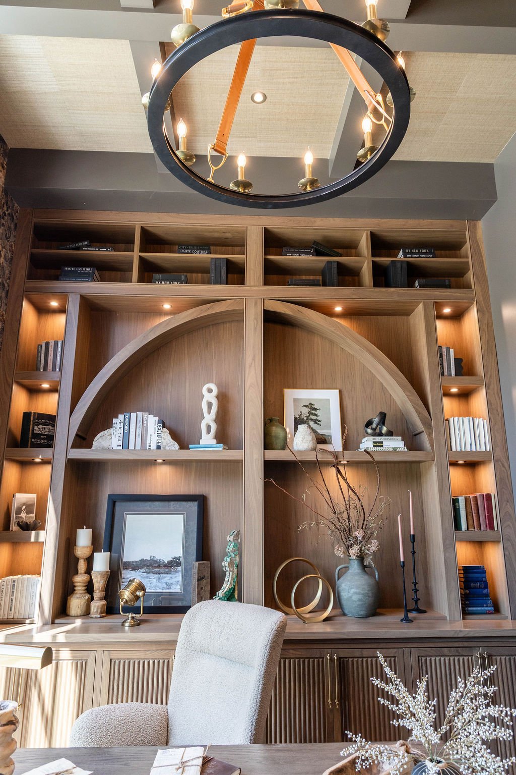 Library-style office with full-height shelving and accent lighting in a luxury custom home