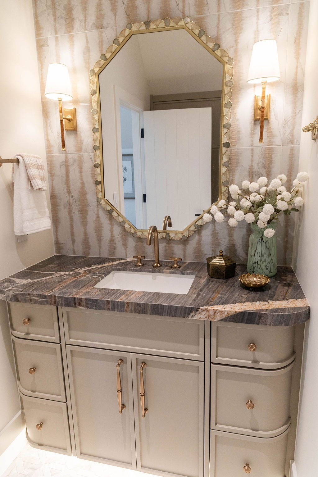 Luxurious bathroom design with octagonal mirror and textured tile wall in a custom home featured in the 2025 Utah Valley Parade of Homes