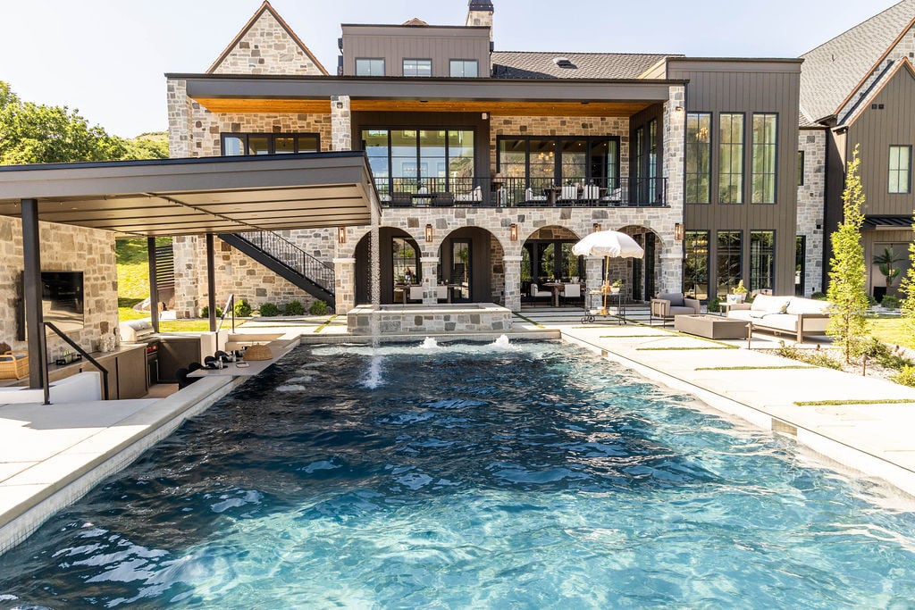 Luxury backyard oasis with pool and covered outdoor kitchen in a custom home featured in the 2025 Utah Valley Parade of Homes