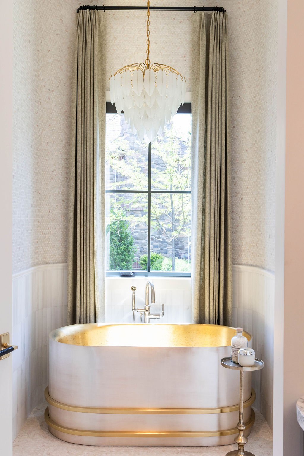 Luxury freestanding tub with gold trim and floor-to-ceiling window in a custom home featured in the 2025 Utah Valley Parade of Homes