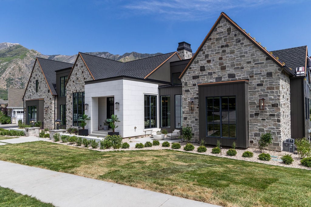 Luxury home exterior with dormer windows and designer landscaping in a custom home featured in the 2025 Utah Valley Parade of Homes