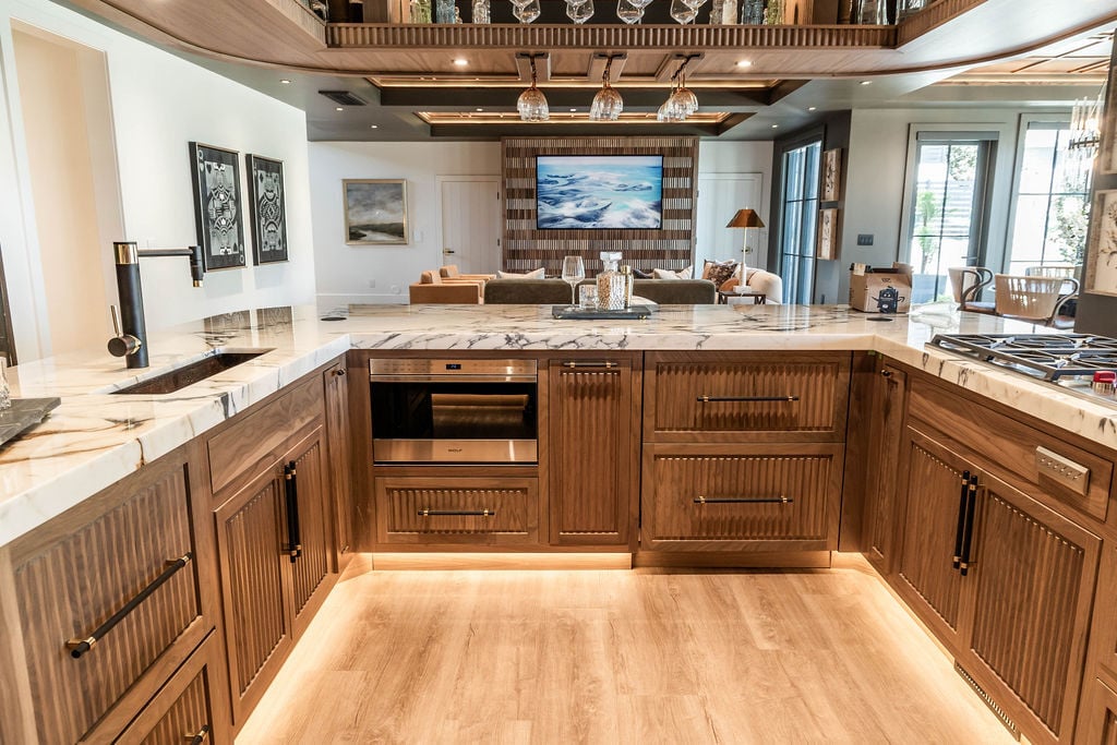 Marble-topped bar area with integrated lighting and custom woodwork in a custom home featured in the 2025 Utah Valley Parade of Homes