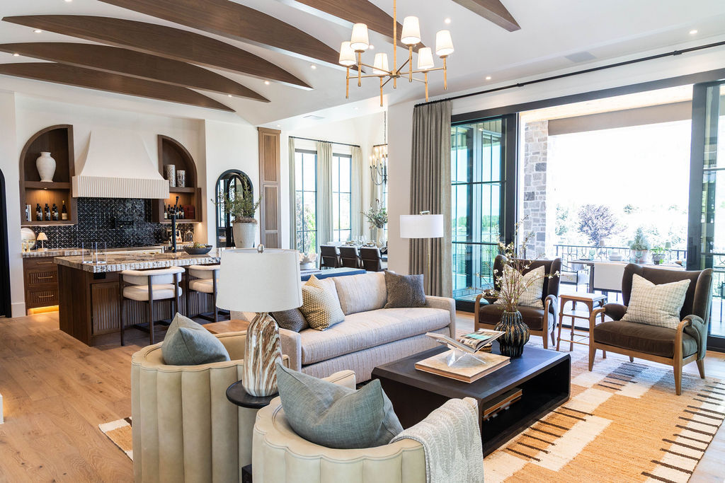 Modern open-concept kitchen and living room with fluted walnut cabinetry and Patagonia Polished countertops in a custom home featured in the 2025 Utah Valley Parade of Homes