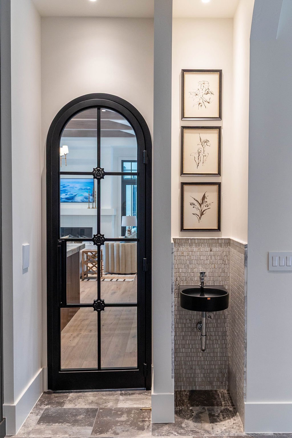 Mudroom with arched black door and tiled floor in a custom home featured in the 2025 Utah Valley Parade of Homes