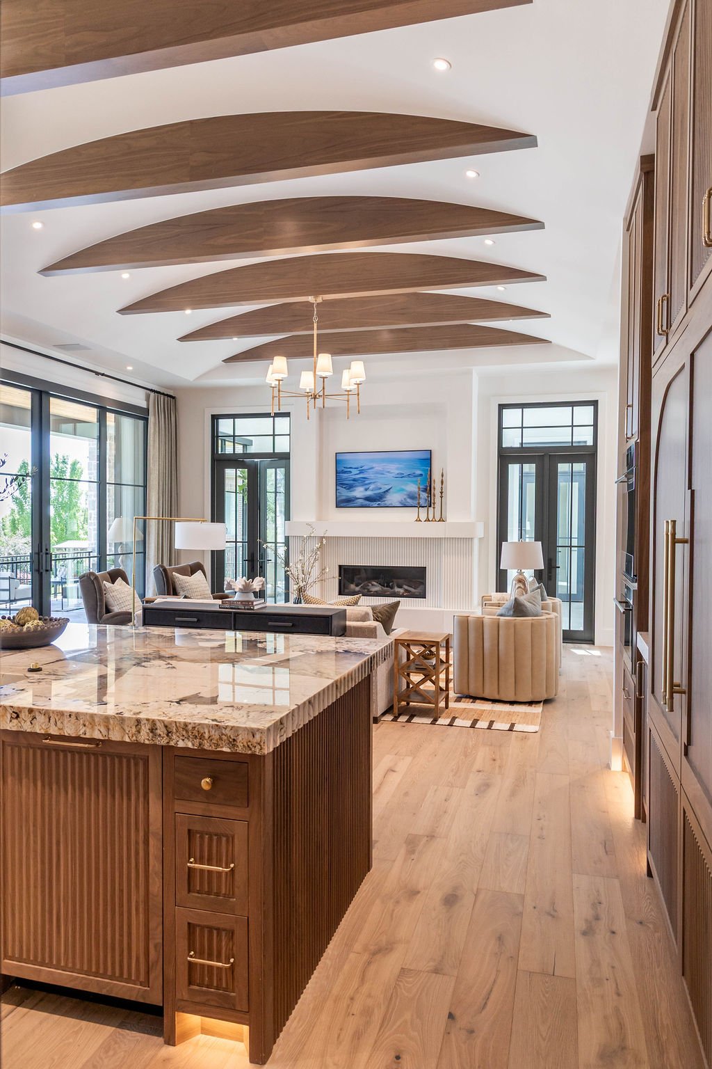 Open-concept kitchen and great room with wood ceiling beams in a custom home featured in the 2025 Utah Valley Parade of Homes