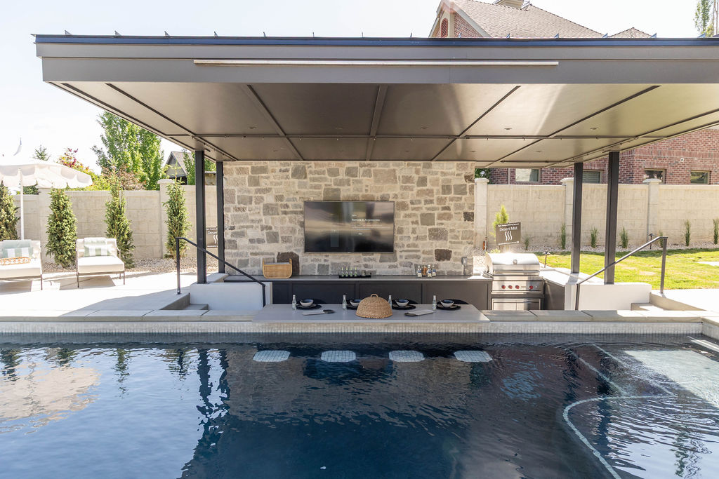 Outdoor kitchen and swim-up pool bar area outside of a custom home featured in the 2025 Utah Valley Parade of Homes