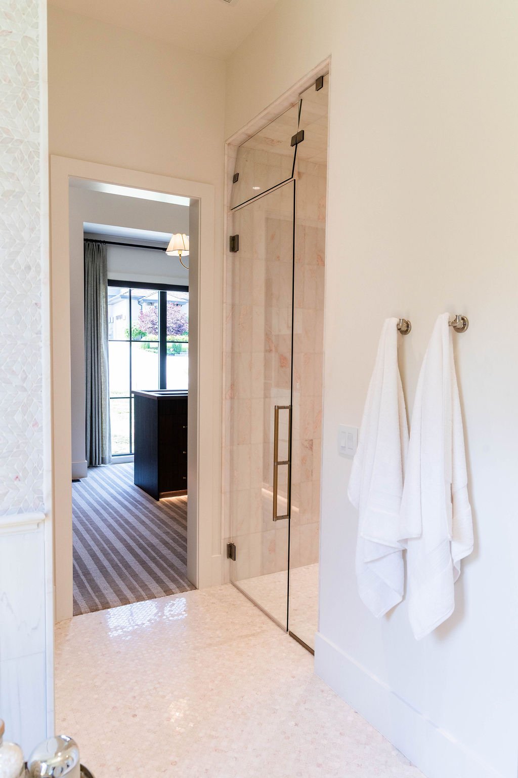 Primary bath view featuring glass shower enclosure and striped Stanton carpet outside in a custom home featured in the 2025 Utah Valley Parade of Homes