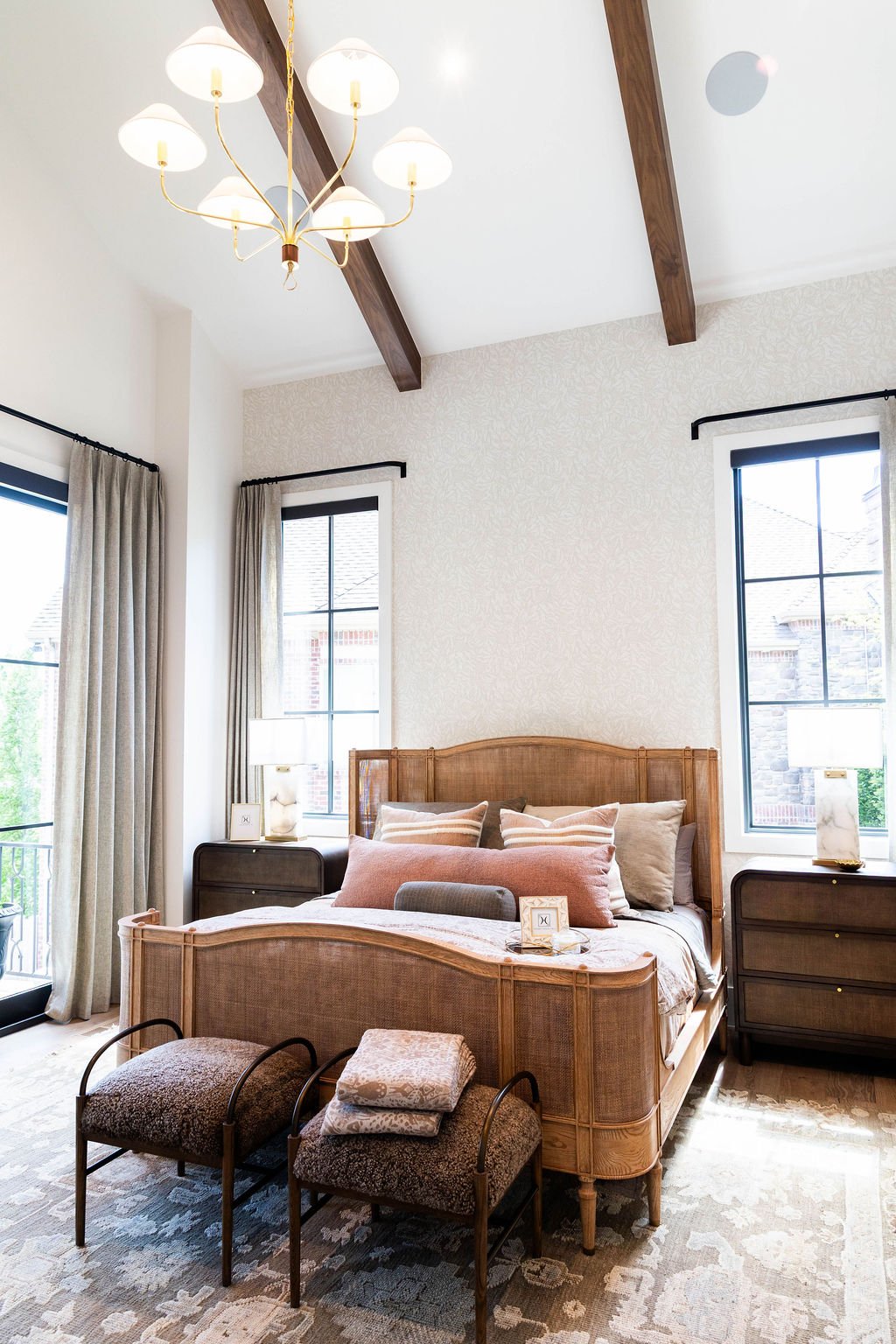 Primary bedroom with vaulted ceiling, wood beams, and soft white walls in a custom home featured in the 2025 Utah Valley Parade of Homes