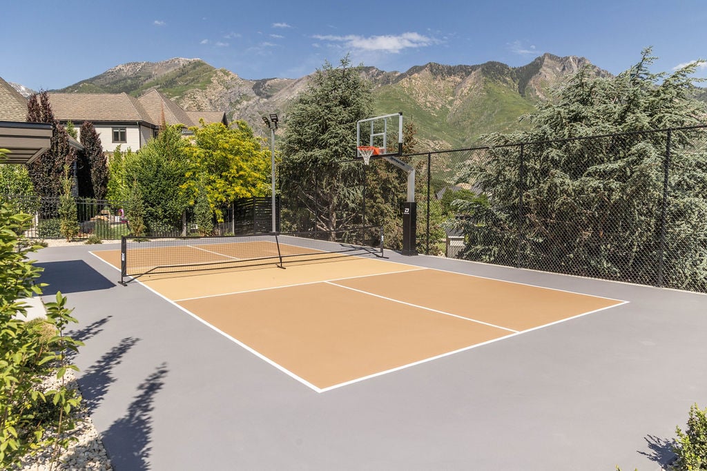Private sport court with fencing and mountain views outside of a custom home featured in the 2025 Utah Valley Parade of Homes