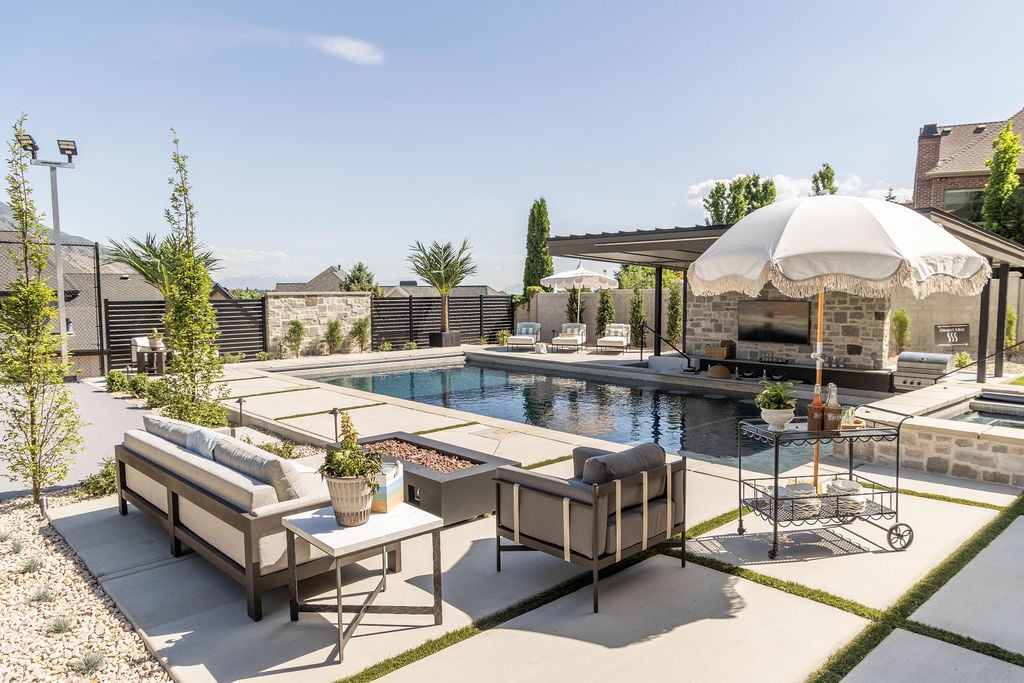 Resort-style backyard with pool and lounge areas in a custom home featured in the 2025 Utah Valley Parade of Homes