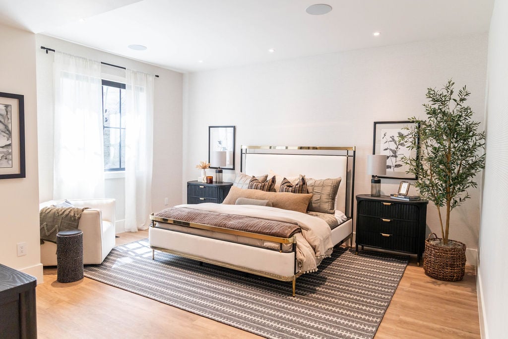 Spacious bedroom with modern decor and natural light in a custom home featured in the 2025 Utah Valley Parade of Homes