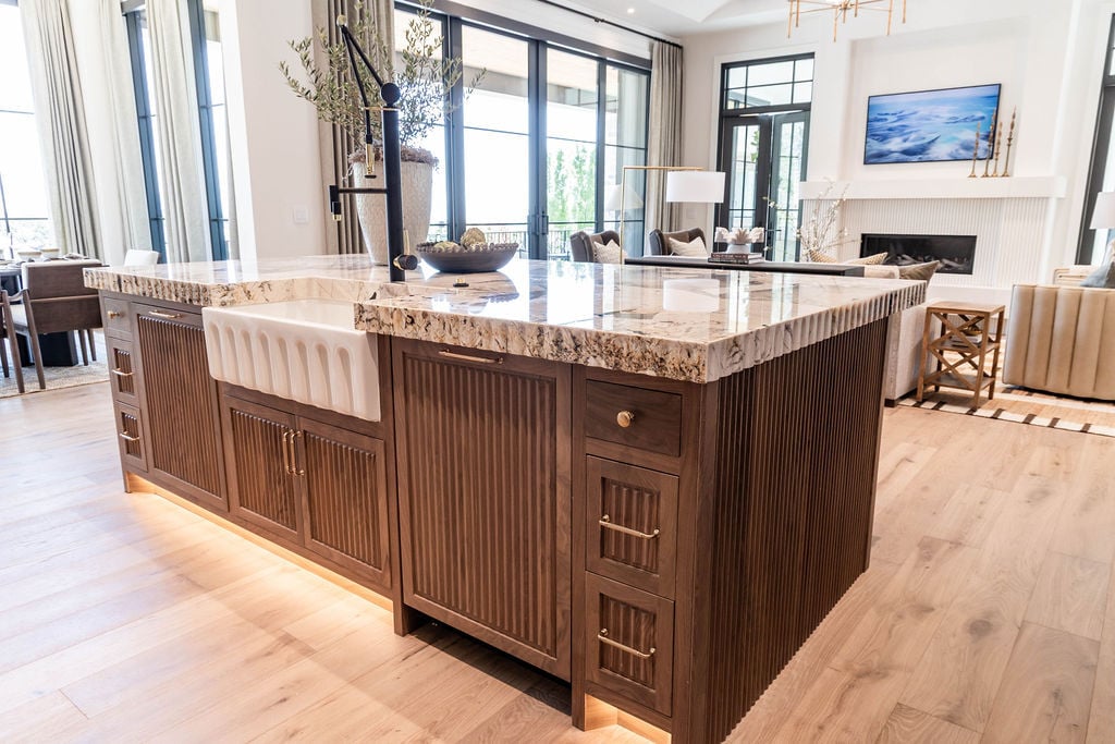 Statement kitchen island with quartzite countertops and apron sink in a custom home featured in the 2025 Utah Valley Parade of Homes