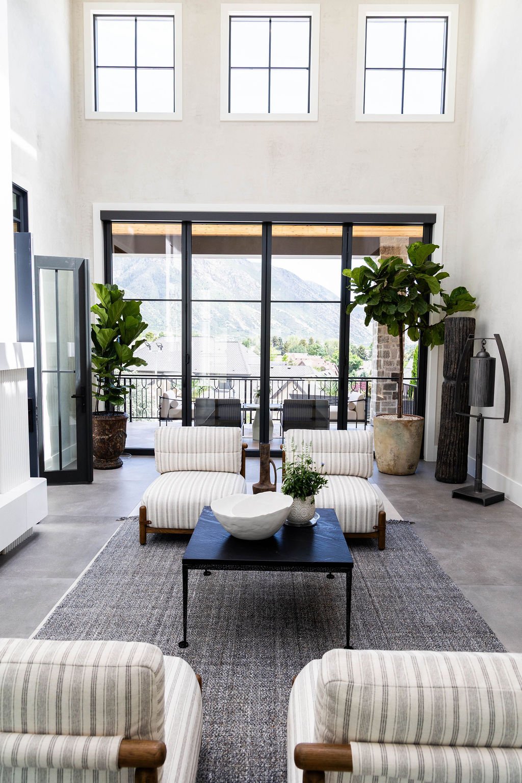 Striped armchairs and view-filled windows in E Builders’ custom 2025 Utah Parade Home courtyard