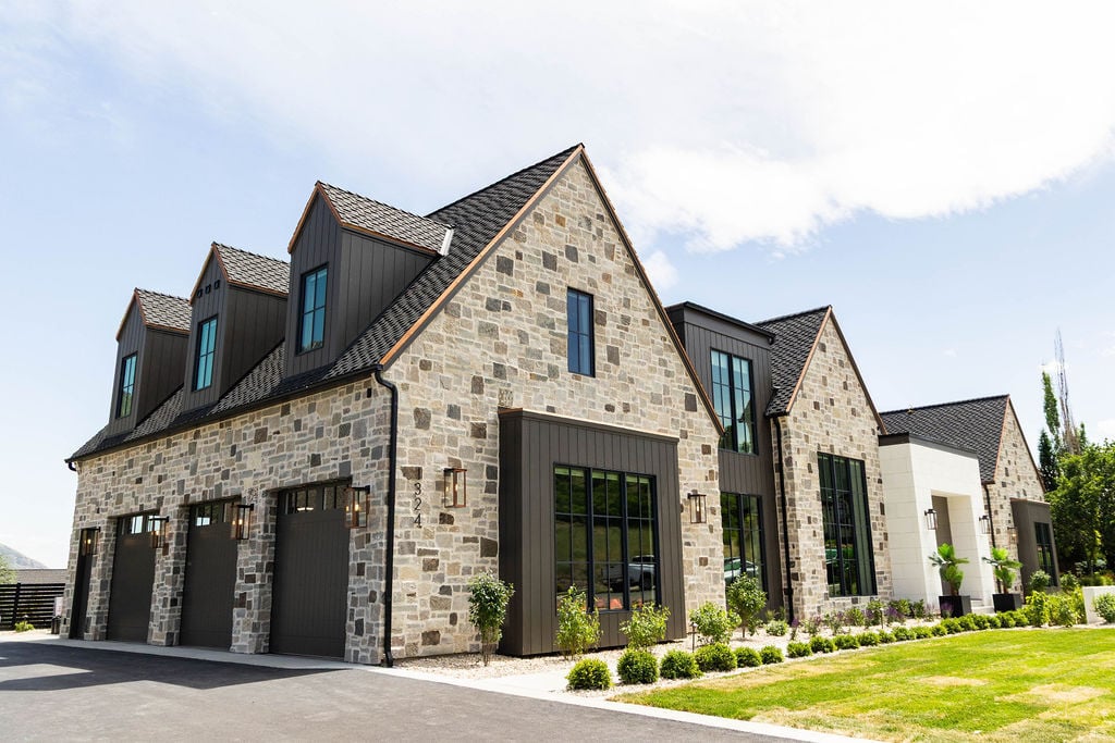 Sweeping side view of luxury residence with black window framing and pitched rooflines in the 2025 Utah Valley Parade of Homes
