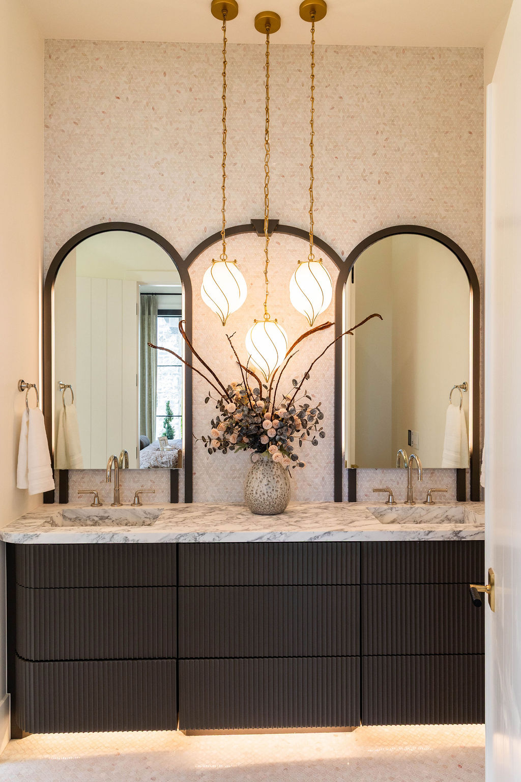 Three arched mirrors and pendant lights above marble vanity in a custom home featured in the 2025 Utah Valley Parade of Homes