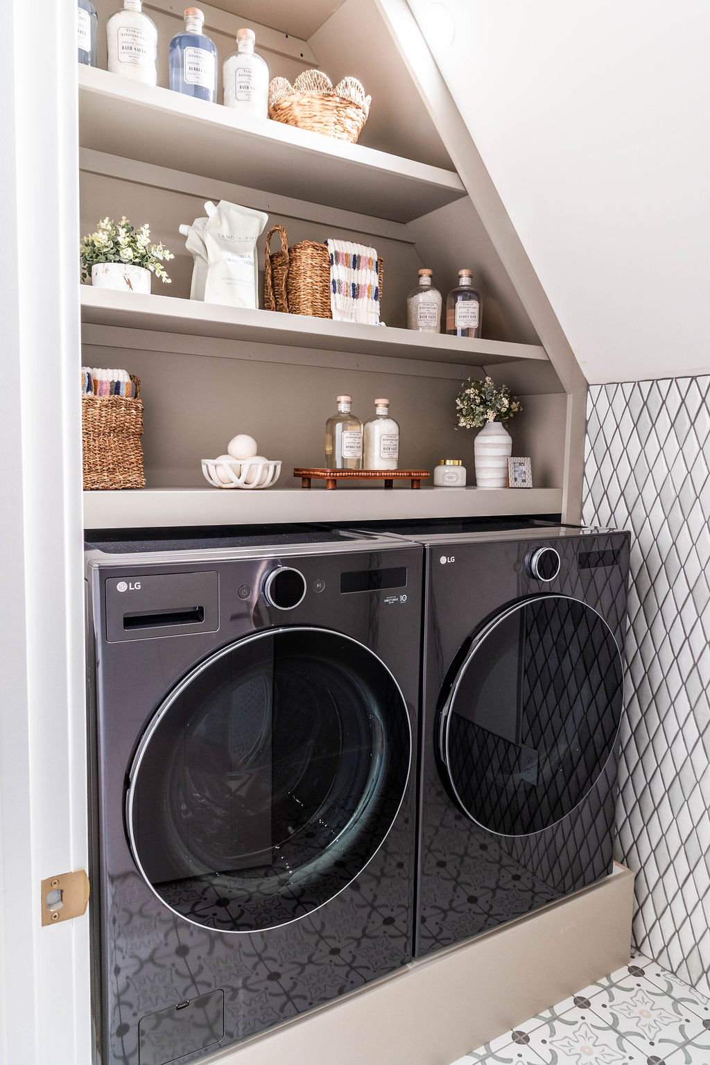 Upstairs laundry nook with LG washer-dryer and open shelving in a custom home featured in the 2025 Utah Valley Parade of Homes