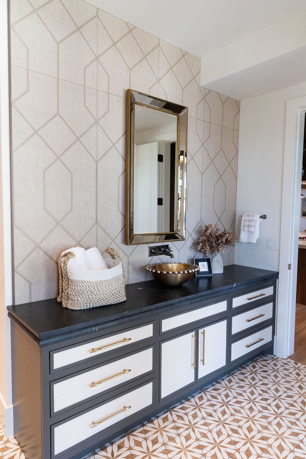Vanity with dark stone top and textured cabinetry in a custom home featured in the 2025 Utah Valley Parade of Homes.