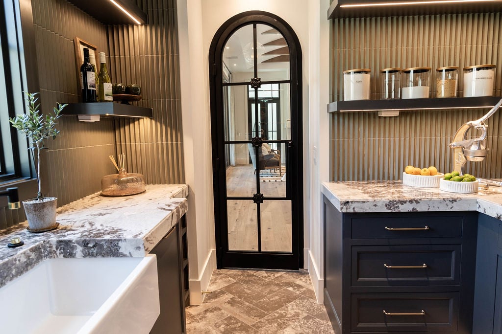 Walk-in pantry with marble countertops and custom cabinetry in a custom home featured in the 2025 Utah Valley Parade of Homes