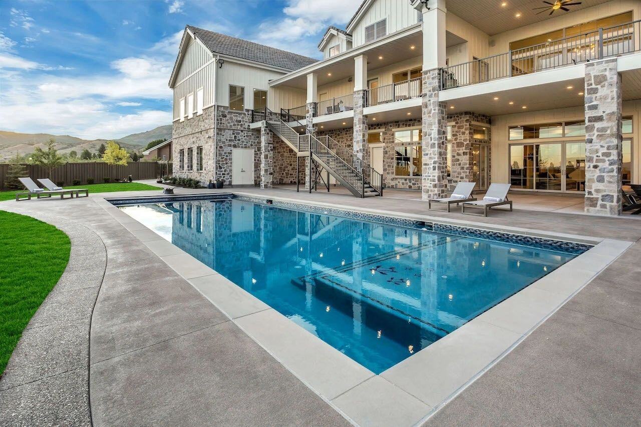 Backyard pool with stone patio in a custom home in Utah built by E Builders