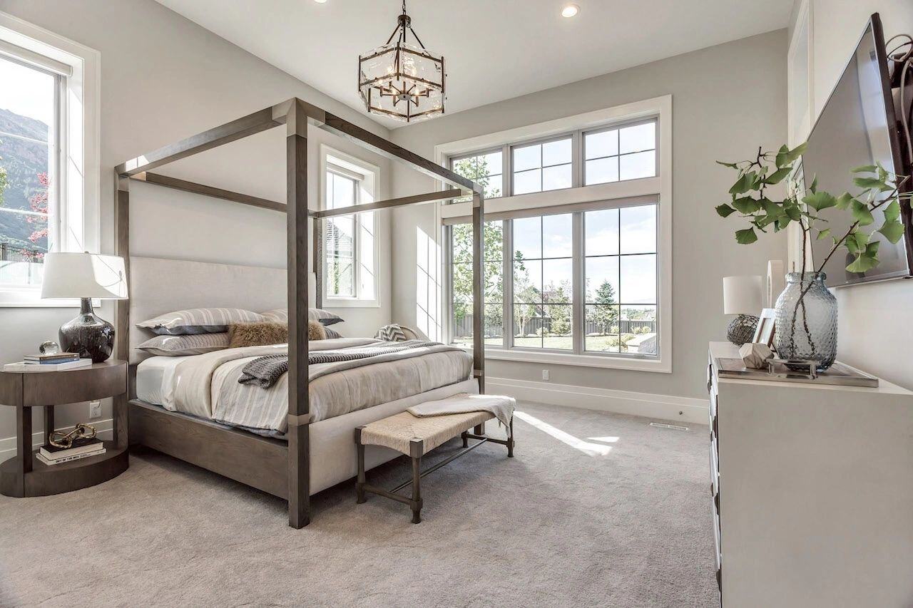Basement bedroom with canopy bed and large windows in a custom home in Utah built by E Builders