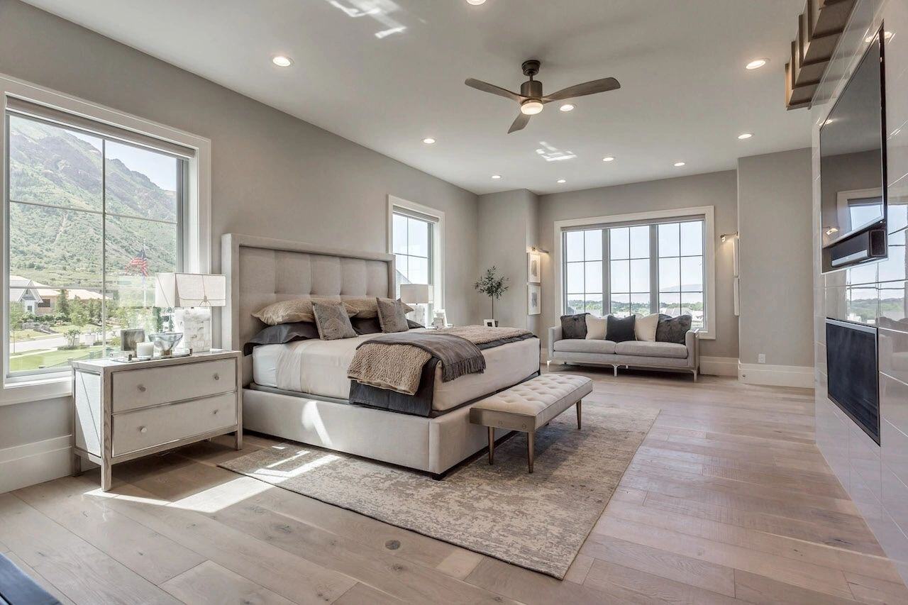 Luxurious master suite with large windows and seating area in a custom home in Utah built by E Builders