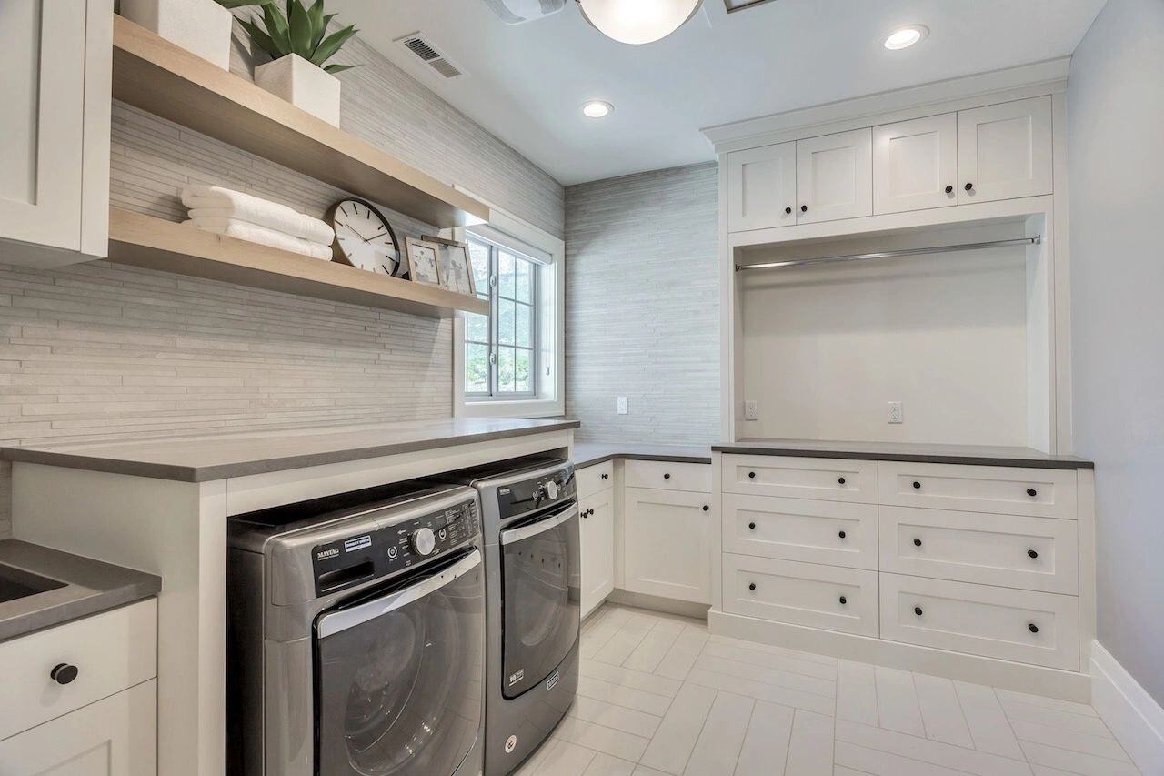 Modern upstairs laundry room with floating shelves in a custom home in Utah built by E Builders