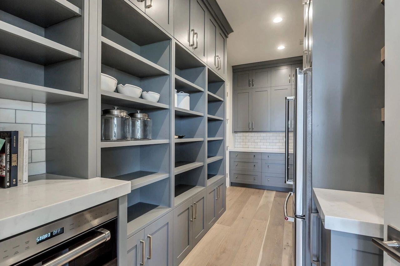 Walk-through butler’s pantry with open shelving in a custom home in Utah built by E Builders